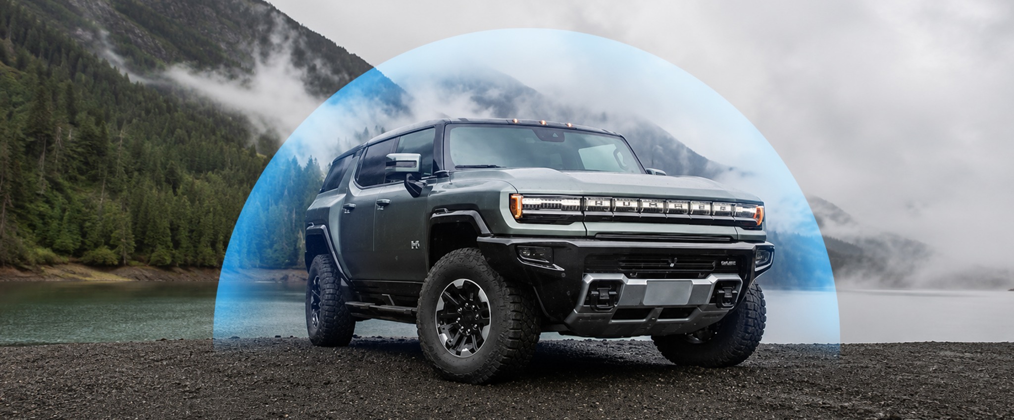 Hummer protegido por una esfera azul frente a un lago y montañas